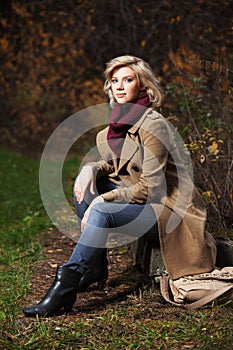 Young fashion blond woman in autumn forest