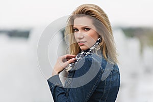 Young fashion blonde woman in denim jacket and silk scarf