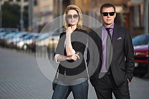 Young fashion business couple walking on city street