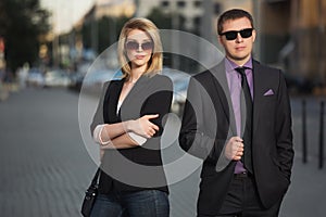 Young fashion business couple walking on city street