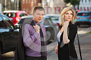 Young fashion business couple walking on city street