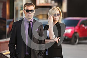 Young fashion business couple walking on city street