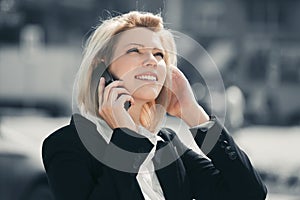 Young fashion business woman calling on cell phone in city street