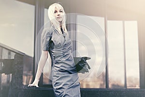 Young fashion business woman with handbag at office building