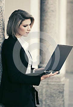 Young fashion business woman with laptop at office building