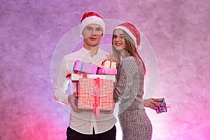 Young, fashion couple celebrating St. Valentine`s Day giving presents to each other