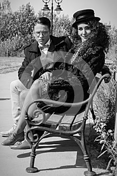 Young fashion elegant stylish retro couple sitting on bench