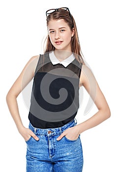 Young fashion girl in jeans and glasses posing isolated