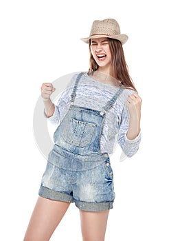 Young fashion girl in jeans overalls with yes gesture isolated