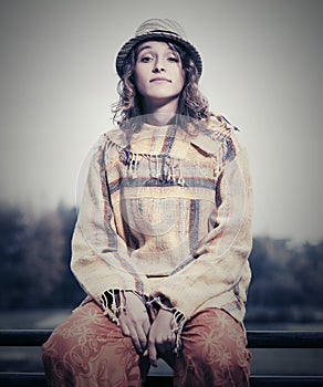 Young fashion hipster woman sitting on handrail outdoor