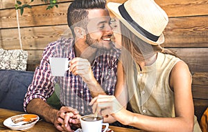 Young fashion lovers couple at beginning of love story - Handsome man kissing beautiful woman at coffee shop bar - Relationship
