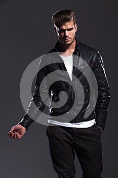 Young fashion male model in leather jacket posing