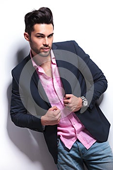 Young fashion man holding hands on suit jacket