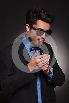 Young fashion man lighting his cigarette