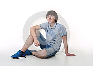 Young fashion man posing in jeans shorts and blue sneakers shoes