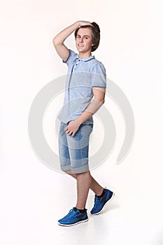 Young fashion man posing in jeans shorts and blue sneakers shoes