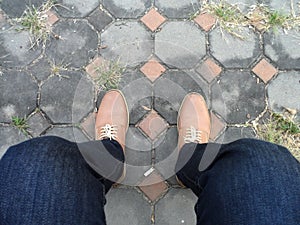 Young fashion man`s legs in jeans and boots on floor