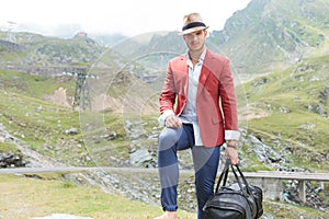 Young fashion man with voyage bag outdoor