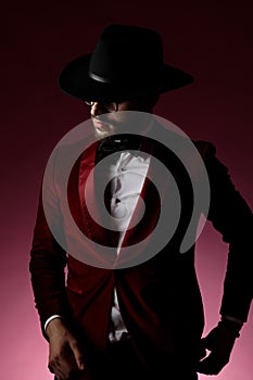 Young fashion model wearing red velvet tuxedo and hat