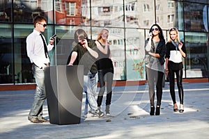 Young fashion people calling on cell phones outdoor