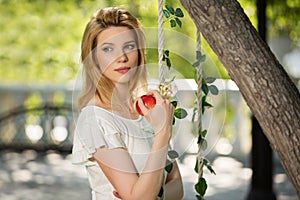 Young fashion woman with apple in a city park