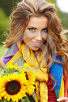 Young fashion woman with a bouquet of sunflowers