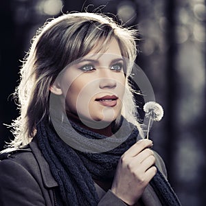 Young fashion woman in classic beige coat walking in autumn park