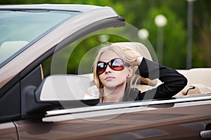 Young fashion woman driving a convertible car