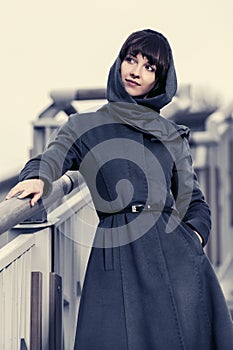 Young fashion woman in gray classic coat and headscarf