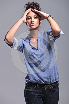 Young fashion woman holding her hands on her head.