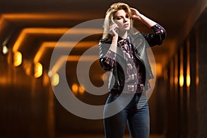 Young fashion woman in leather jacket calling on mobile phone