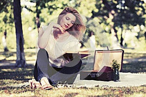 Young fashion woman reading a book in city park