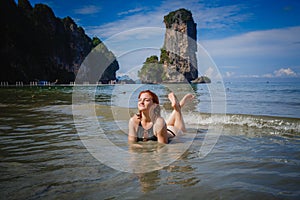 Young fashion woman relax on the beach. Happy island lifestyle. White sand, blue cloudy sky and crystal sea of tropical beach.