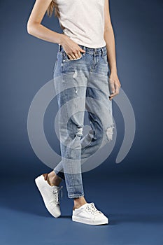 Young fashion woman`s legs in blue denim jeans