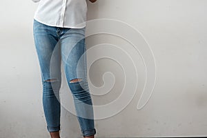 Young fashion woman`s legs in ripped Jeans