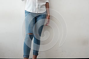 Young fashion woman`s legs in ripped Jeans