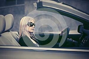 Young fashion woman in sunglasses driving convertible car