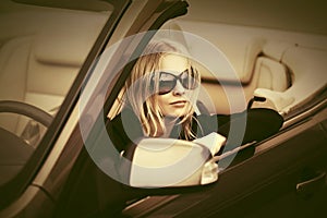 Young fashion woman in sunglasses driving convertible car