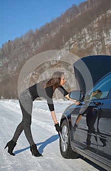 Young fashion woman trying to fix the car