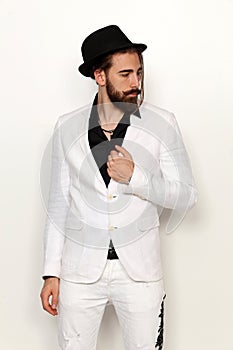 Young, fashionable male model with long hair and beard posing in studio on isolated background. Fashion, business, modeling