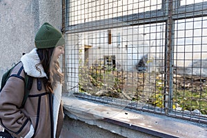 Young fashionable woman in ghetto urban street style wardrobe on the street. Different look female with cool attitude outdoor