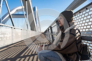 Young fashionable woman in ghetto urban street style wardrobe on the street. Different look female with cool attitude outdoor