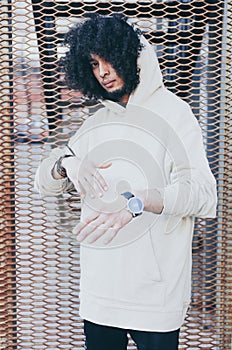 Young fashionably dressed man in hoodies and black jeanse posing on the street. Young fashion, Streetstyle.