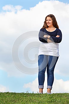 Young fat girl stands at grass