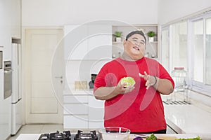 Young fat man holding a cabbage to make a salad