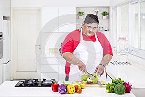 Young fat man mixing a bowl of fresh salad