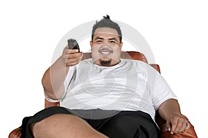 Young fat man watching television on studio