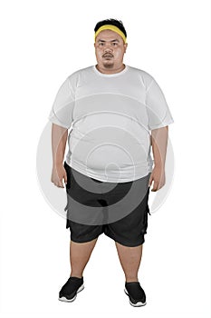 Young fat man wearing sportswear on studio