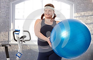 Young fat woman exercising with fit ball