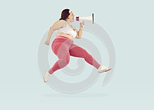 Young fat woman screaming with mouthpiece on studio blue background. Advertising concept.